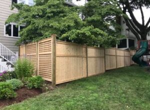 Wooden fence with lattice in backyard.