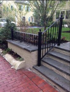 Garden steps with black wrought iron railing.