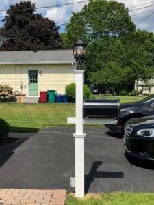 Mailbox with lantern on suburban driveway.