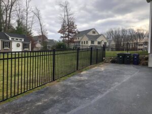 Suburban yard with metal fence and houses.
