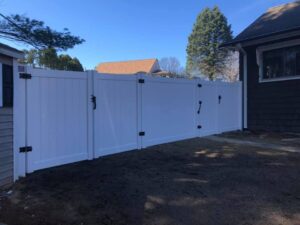 White fence beside houses and trees.