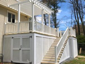 White patio with stairs and lattice panels.