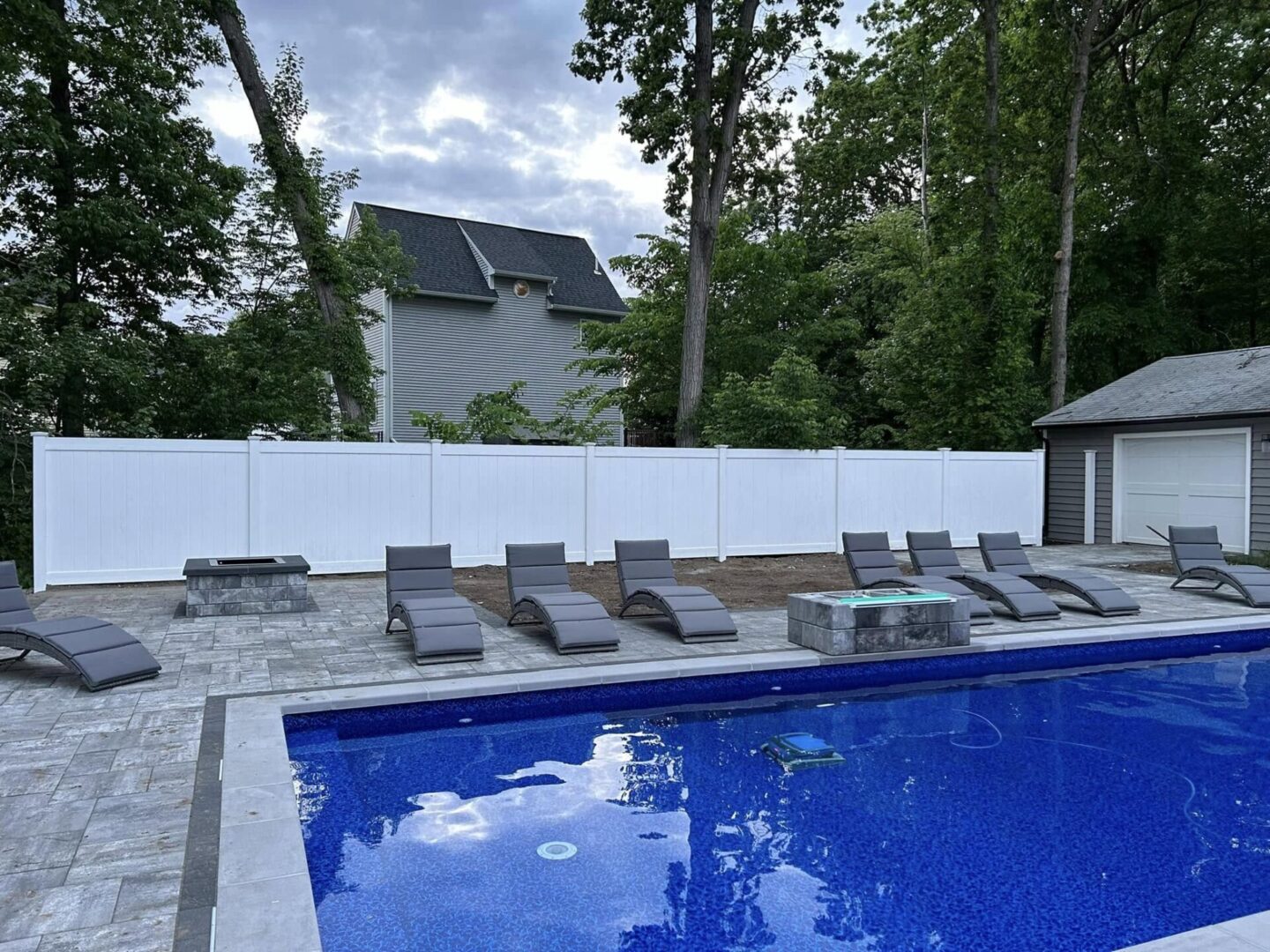 449218363_910119937795234_742588458824855842_n Backyard pool with lounge chairs and trees.