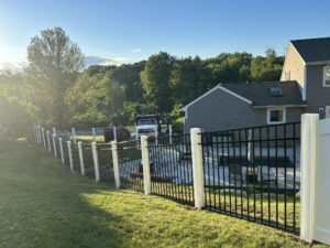 House and fence with sunny backyard.