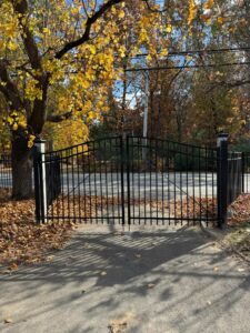 Black gate with autumn leaves around.