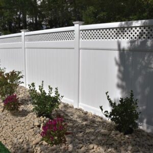 White fence with garden and rocks.