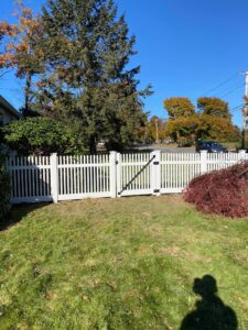 White picket fence with green grass lawn.